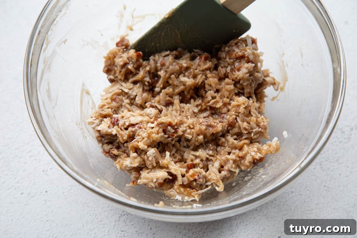 Classic Lazy Daisy Oatmeal Cake Recipe 7 coconut pecan topping in a glass bowl.