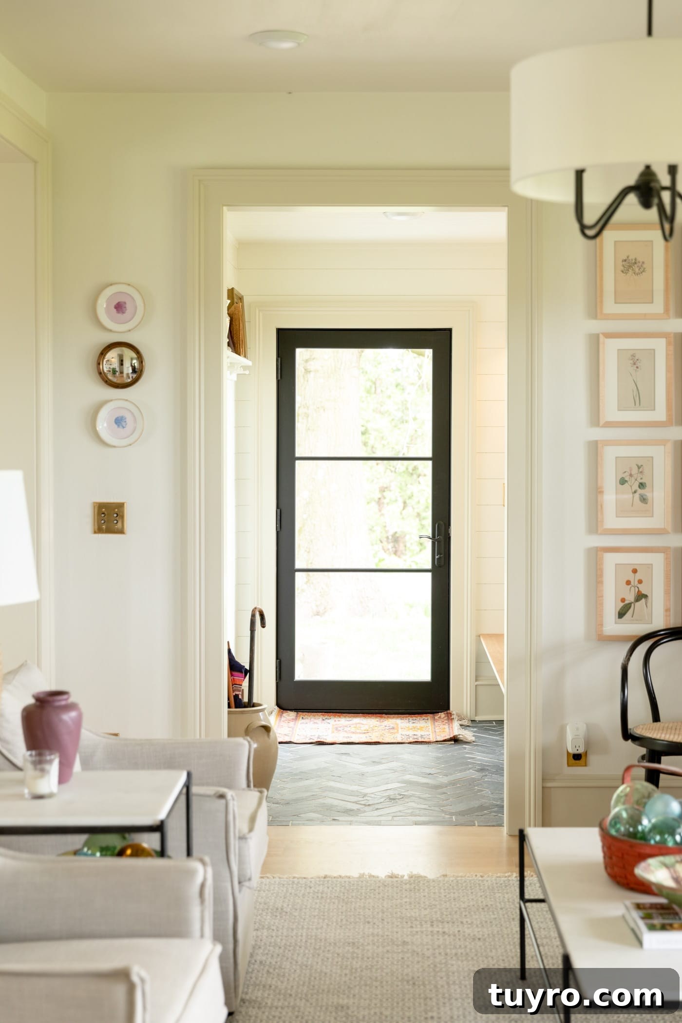 Black French door leading into entryway with black slate flooring and cream colored trim