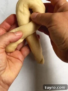 How to Braid Challah: Step-by-Step Visual Guide 9 Demonstrating a challah roll knot, we see the first crossover of the strand.