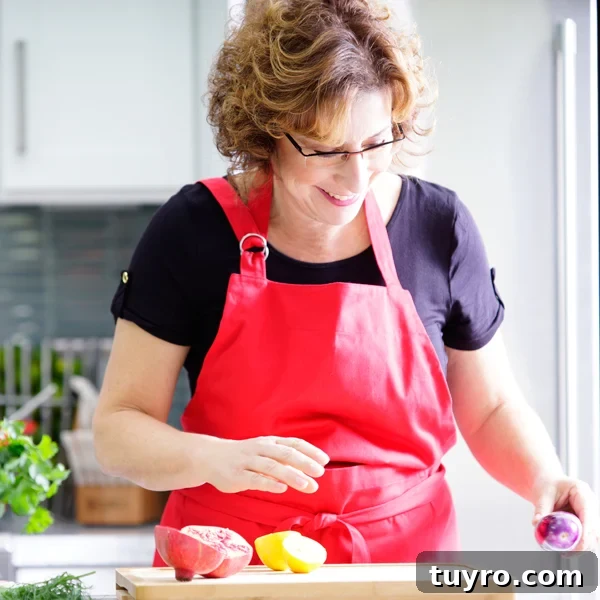 How to Braid Challah: Step-by-Step Visual Guide 12 Beth Lee in red apron looking at vegetables on cutting board