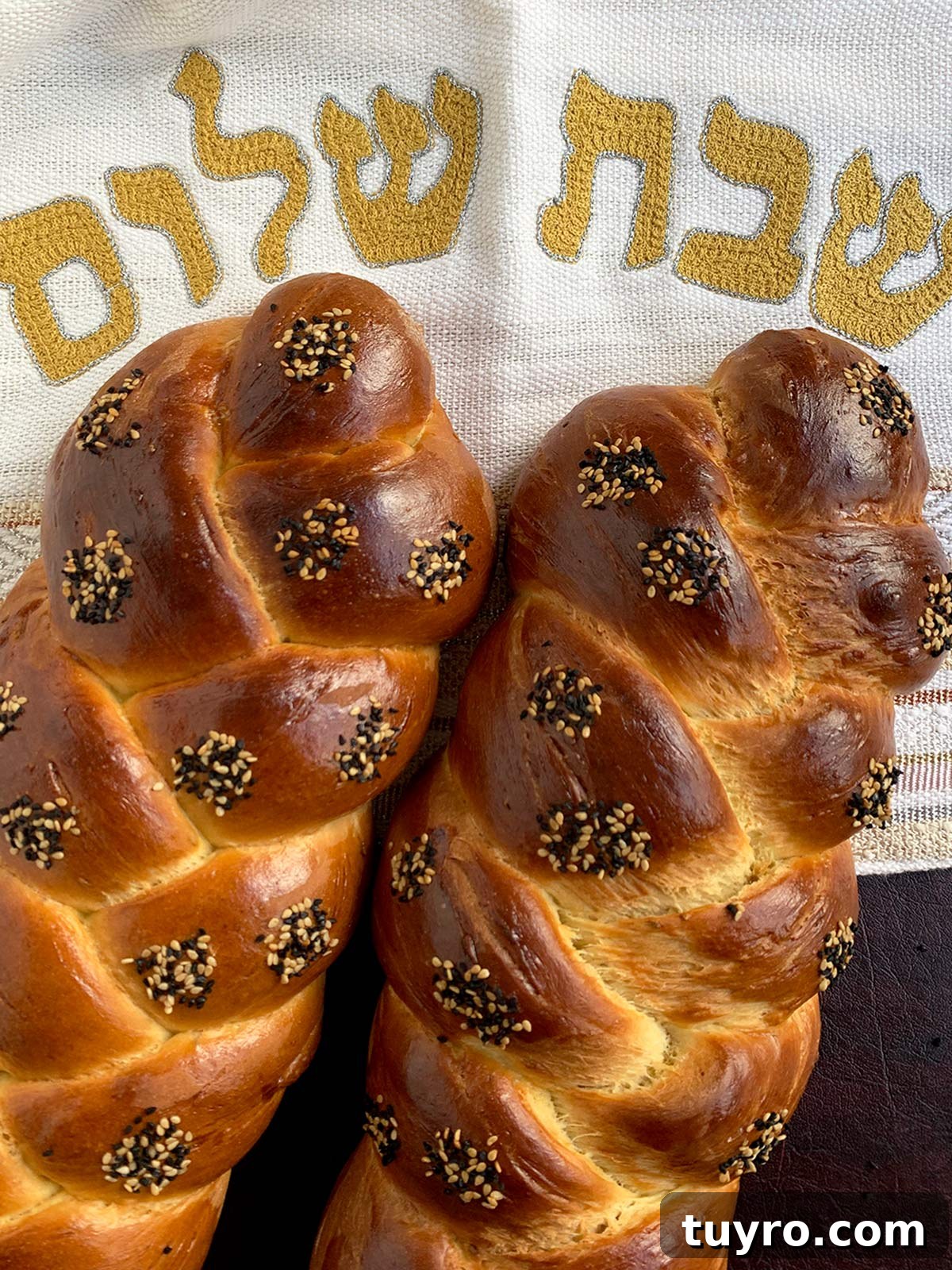 How to Braid Challah: Step-by-Step Visual Guide 4 Two 3-strand challahs side by side near a challah cover.