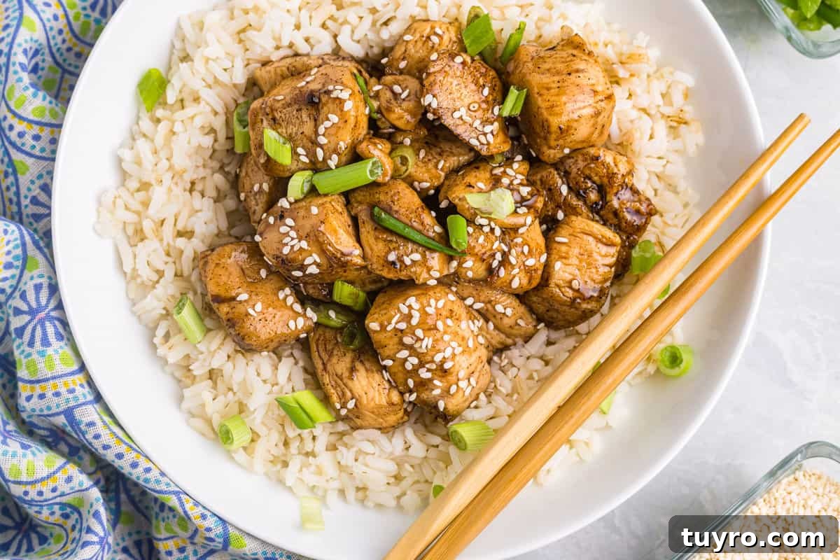 Blackstone Teriyaki Chicken Recipe: Sticky Glazed Griddle Chicken 8 Teriyaki Chicken atop of a bed of rice in shallow bowl with chopsticks