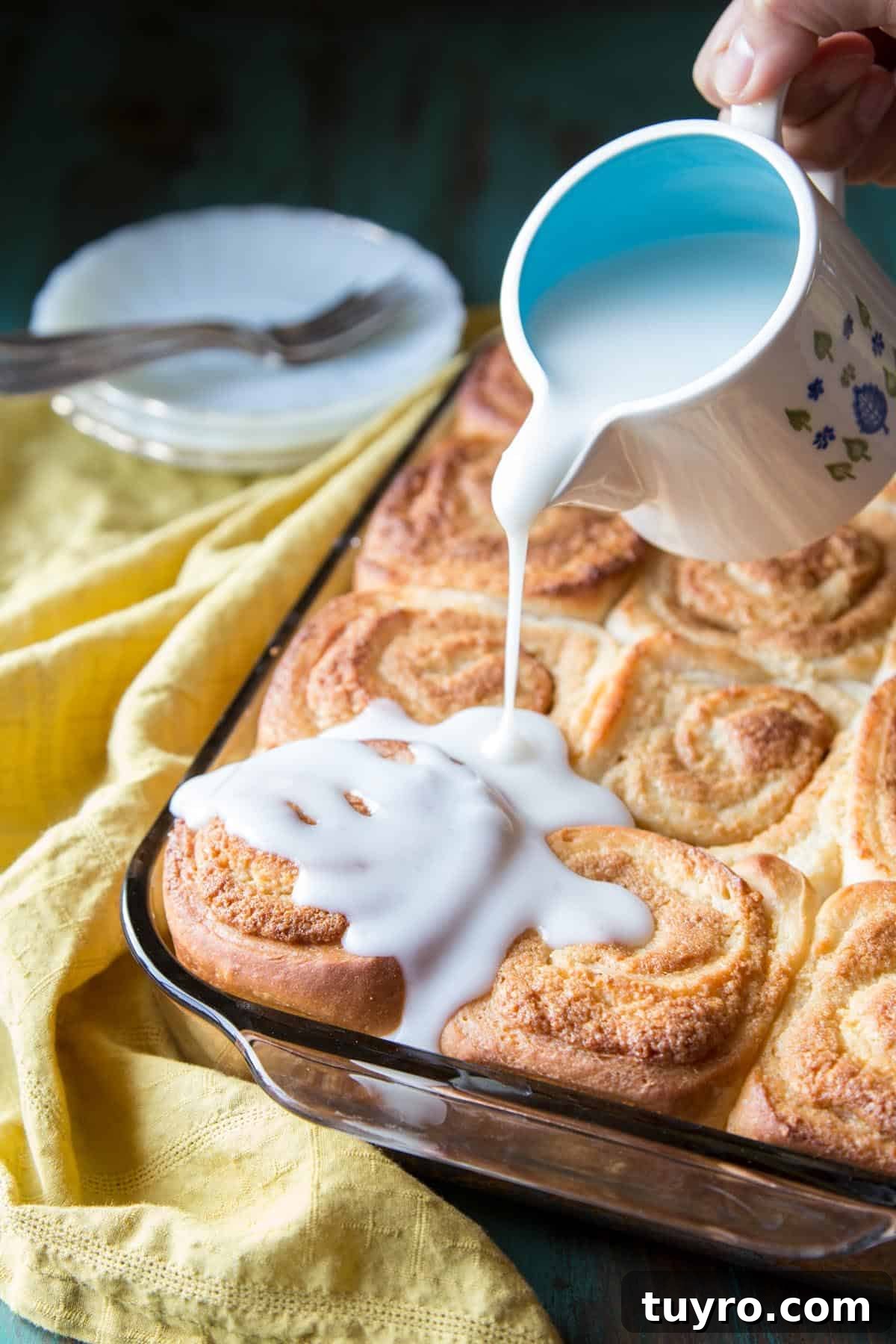 Pouring coconut sauce over baked rolls