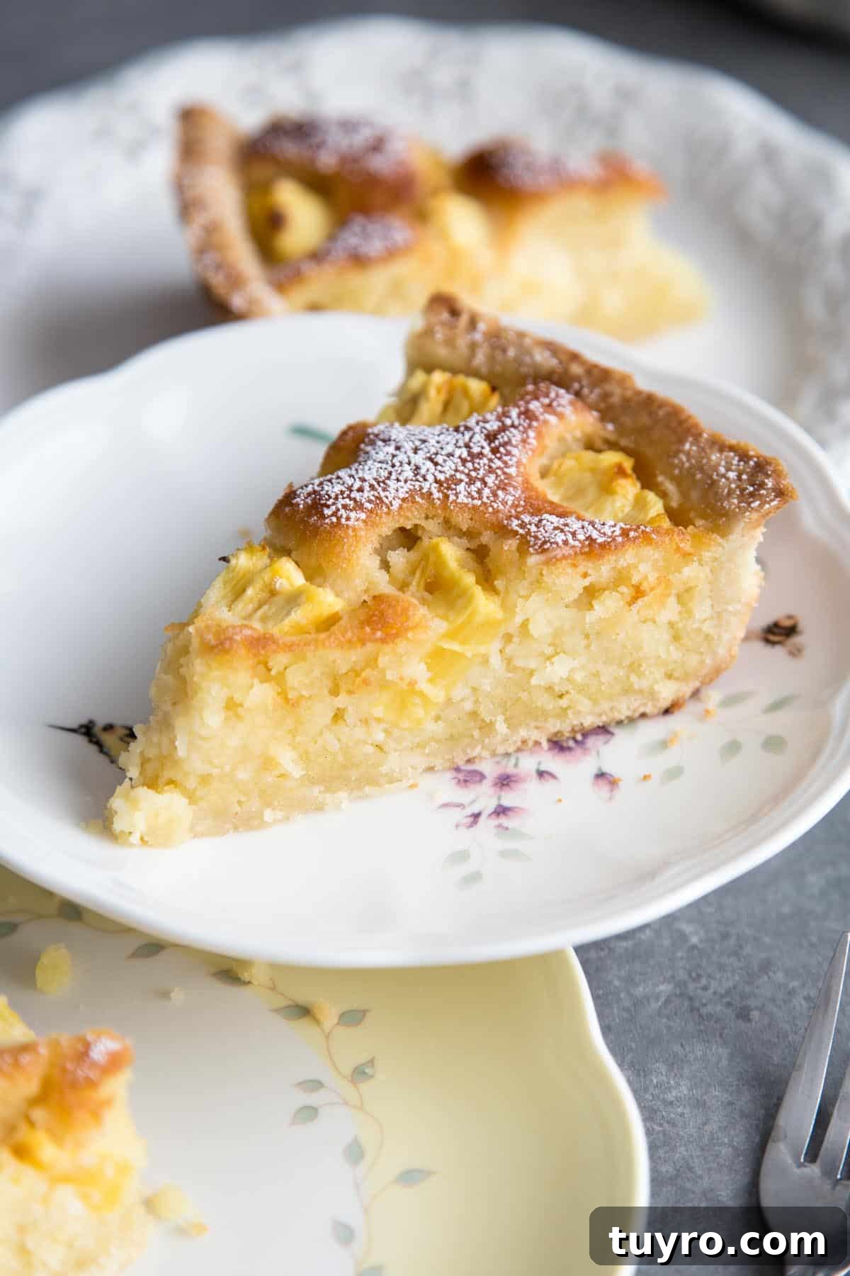 A slice of Pineapple Coconut Frangipane Tart on a plate