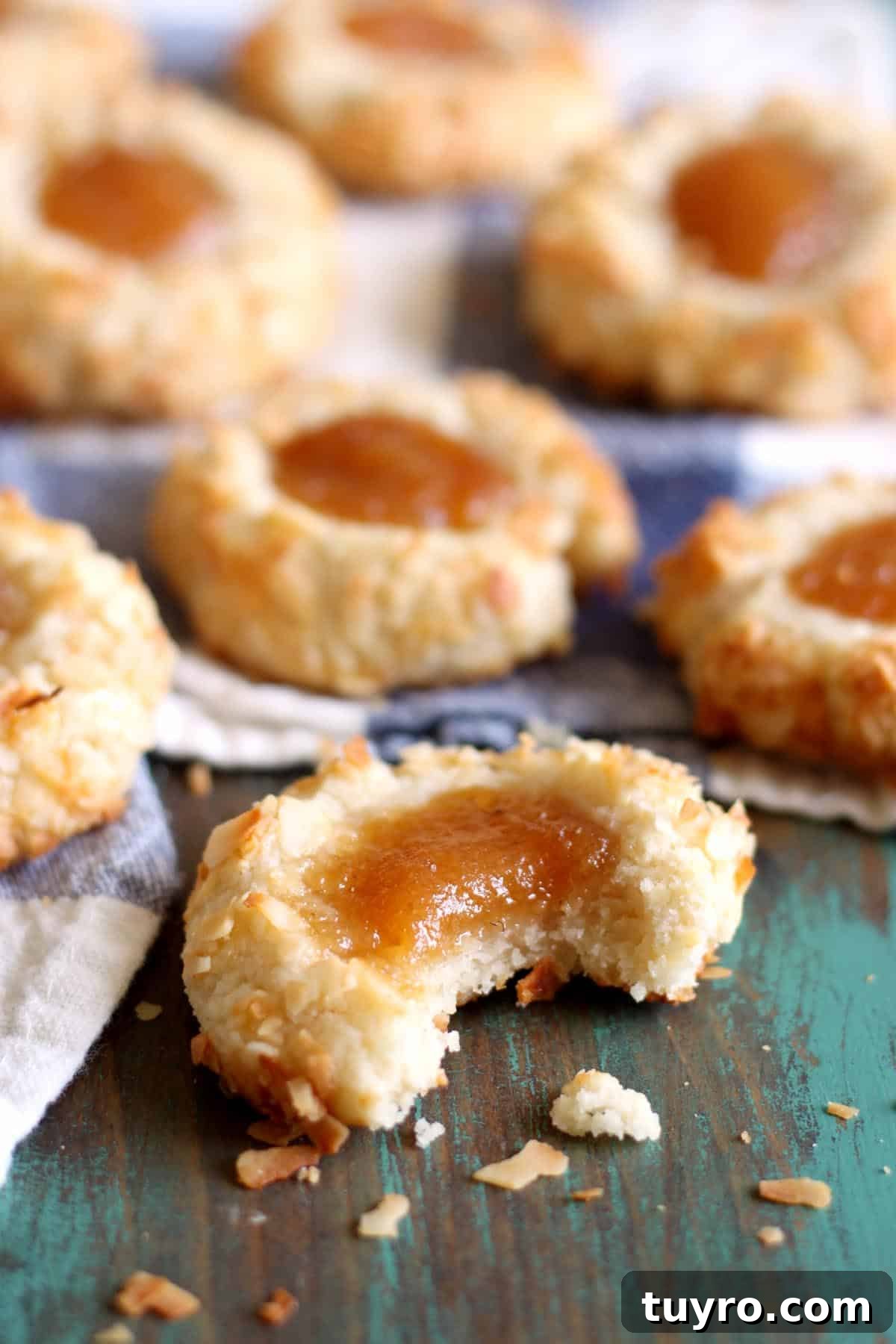 Coconut Guava Thumbprint Cookies covered in coconut flakes and topped with guava jam
