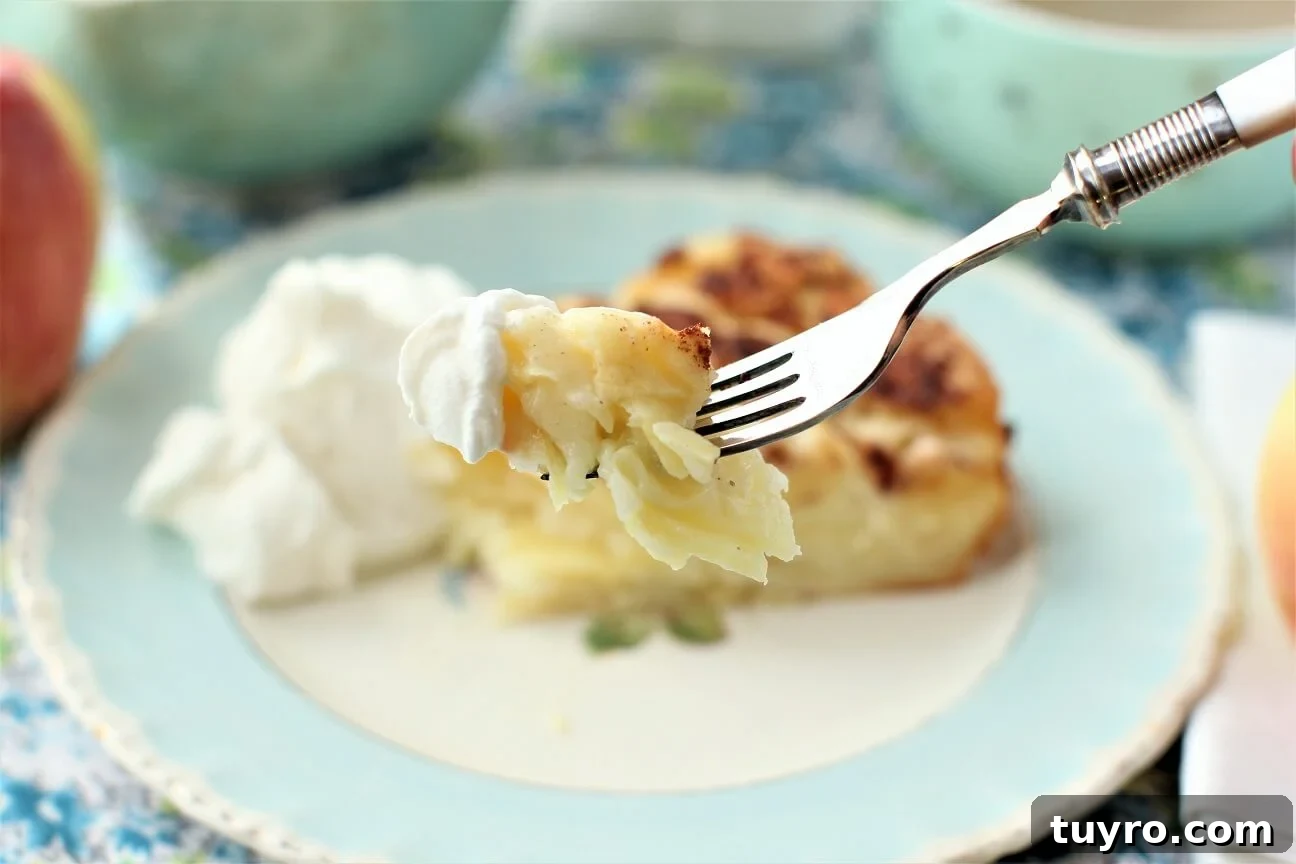 German Crustless Apple Pie — Creamy Apple-Stuffed Kuchen Recipe 7 a forkful of crustless apple pie with a dollop of whipped cream