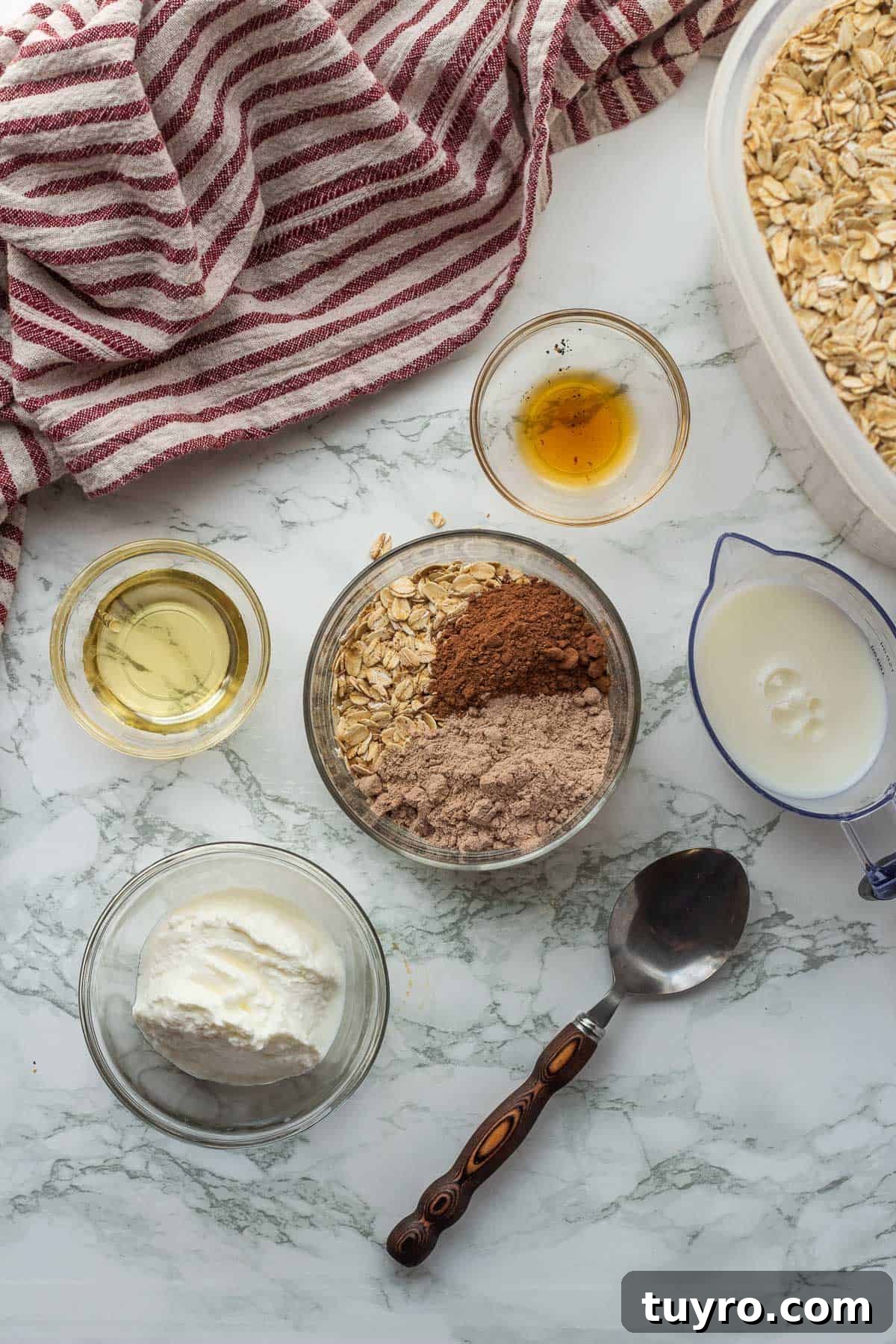 Brownie Batter Overnight Oats Recipe for Indulgent Breakfast 4 Ingredients for brownie batter overnight oats in glass bowls on marble countertop with dish towel.