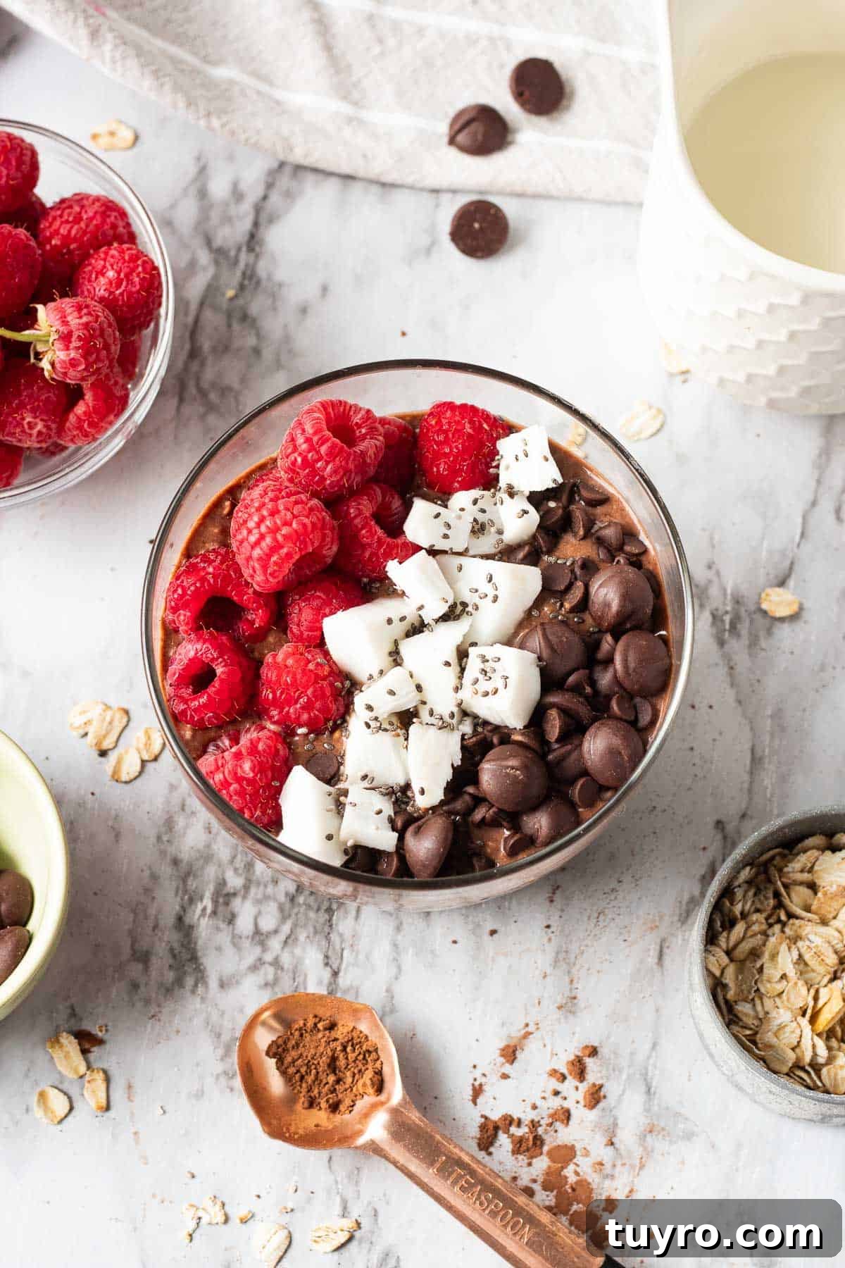 Brownie Batter Overnight Oats Recipe for Indulgent Breakfast 6 Brownie Batter Overnight Oats with spoonful of cocoa powder and bowl of raspberries nearby.
