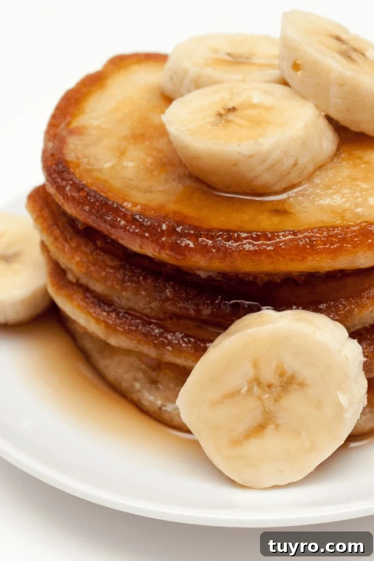 Banana pancakes in a stack with banana slices