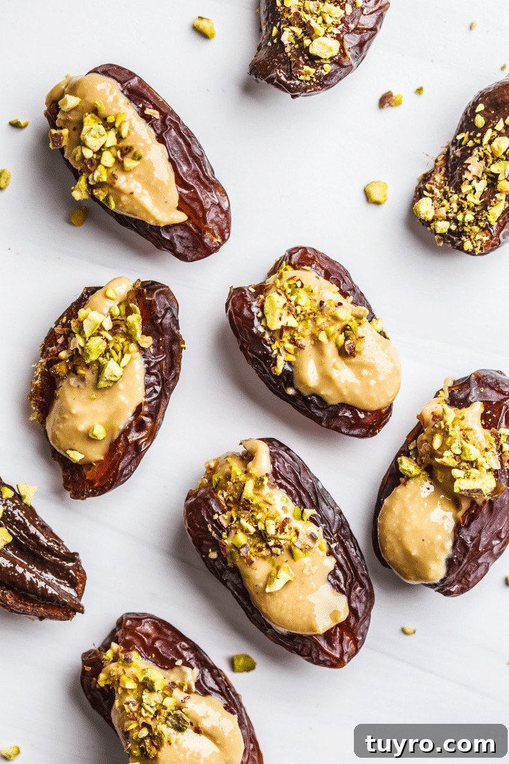 Nut butter stuffed dates with pistachios on a white background