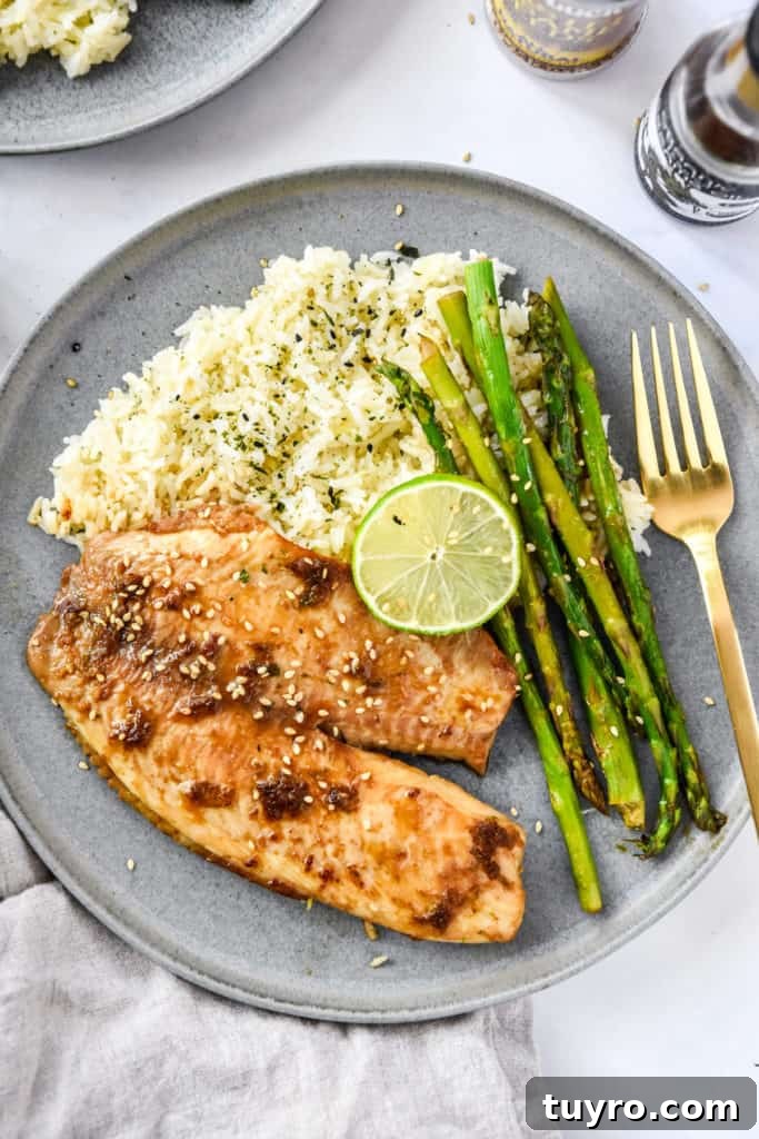 Ginger-Soy Tilapia with Broiled Asparagus Recipe 2 ginger soy tilapia with broiled asparagus on a grey plate with lime.