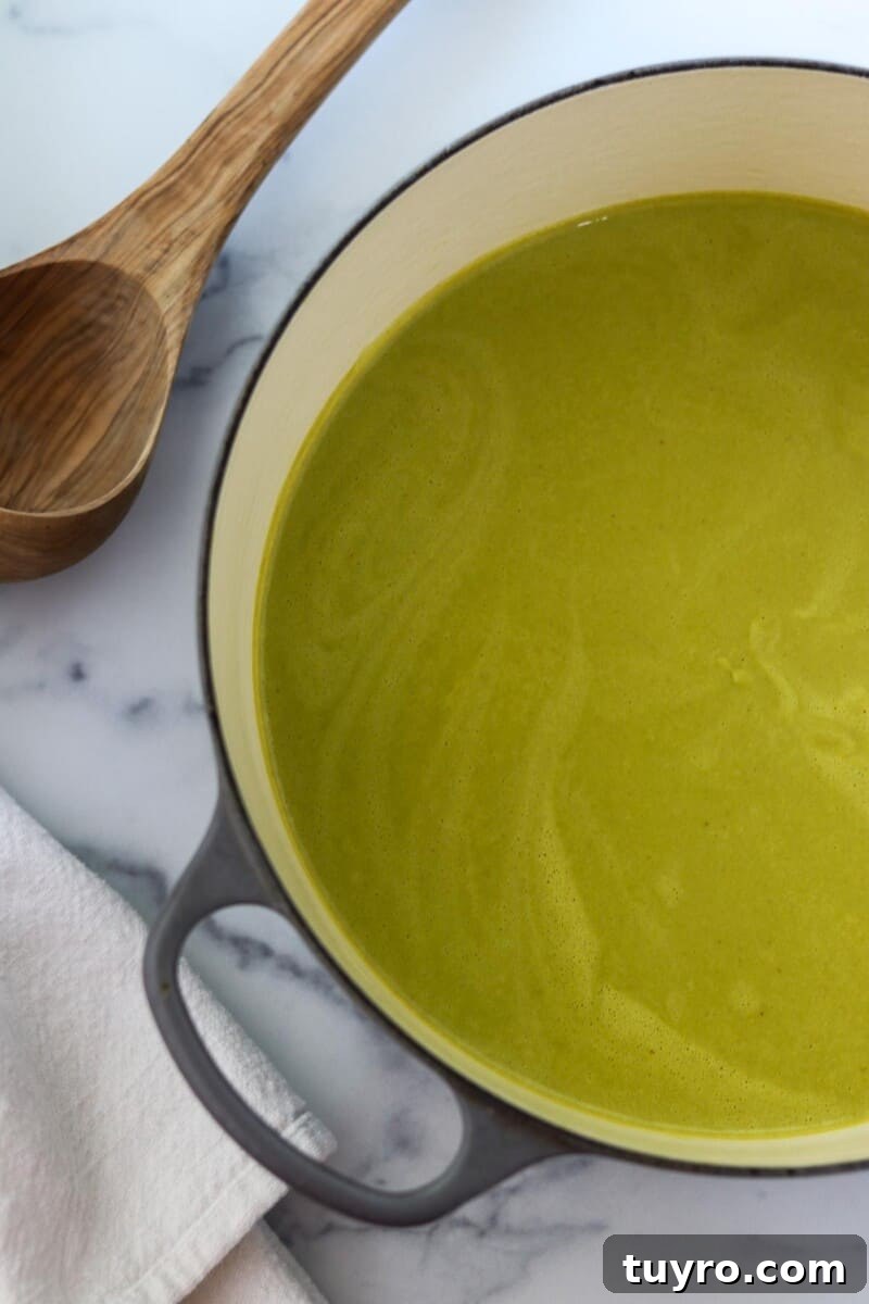 Creamy Asparagus Soup with Leeks and Peas 9 Creamy Asparagus, Leek and Pea Soup in a pot next to a ladle.