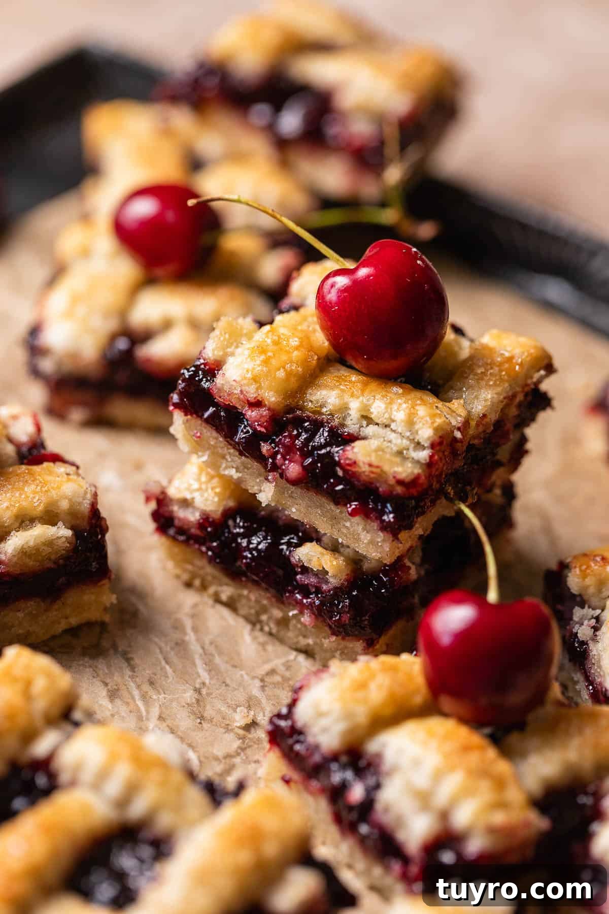 Homemade Cherry Pie Bars with Buttery Crust 5 Two cherry pie bars on top of each other to show the juicy cherry filling.