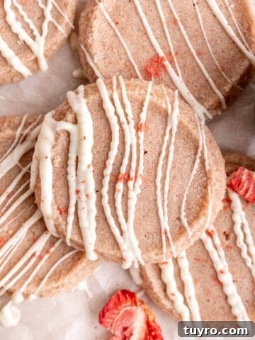Strawberry shortbread cookies with white chocolate drizzled on top.