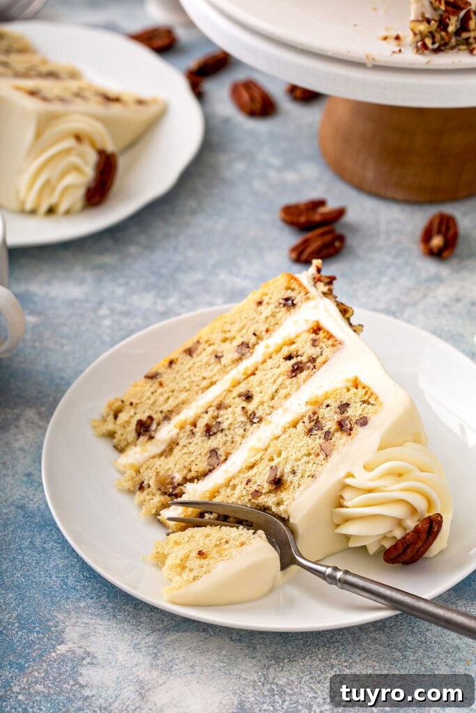 Butter Pecan Cake with Cream Cheese Frosting Recipe 2 Sliced of layered butter pecan cake on a white plate