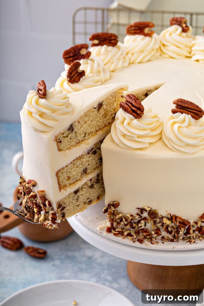 Butter Pecan Cake with Cream Cheese Frosting Recipe 3 A slice of butter pecan cake getting lift from a cake platter