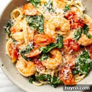 a bowl of tomato spinach shrimp pasta