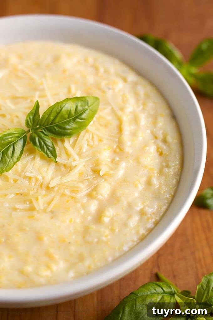 Creamy Instant Pot Polenta Recipe 4 Polenta in a white bowl on a wooden board garnished with basil