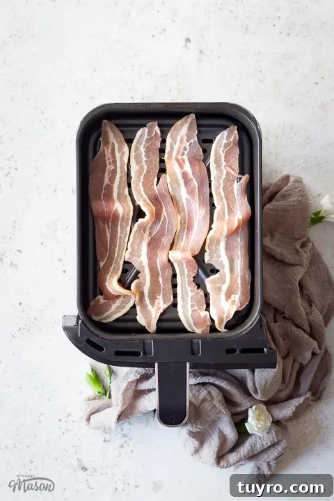 Crispy 10-Minute Air Fryer Bacon Recipe (UK) 7 Uncooked streaky bacon in an air fryer drawer