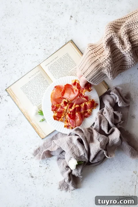 Crispy 10-Minute Air Fryer Bacon Recipe (UK) 8 Someone taking a piece of air fried bacon off a plate