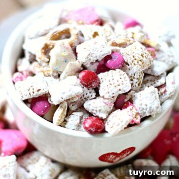 Valentines Day Puppy Chow Recipe 7 A bowl of puppy chow with pink and red candies for Valentine's Day.