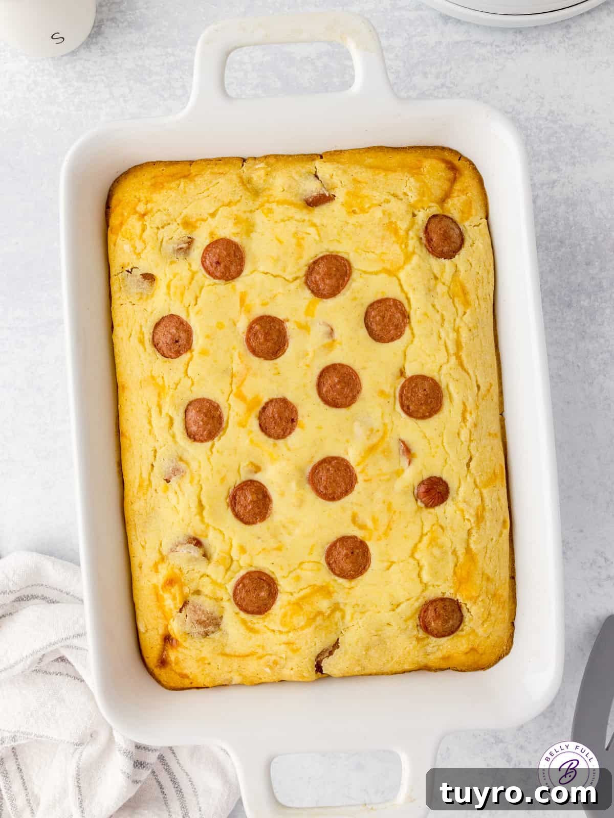 Corn Dog Casserole with Cornbread and Hot Dogs 3 overhead uncut cornbread casserole with hot dogs pieces