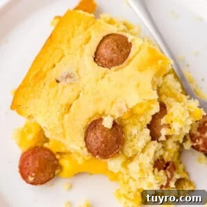 Corn Dog Casserole with Cornbread and Hot Dogs 6 square piece of corn dog casserole on white plate