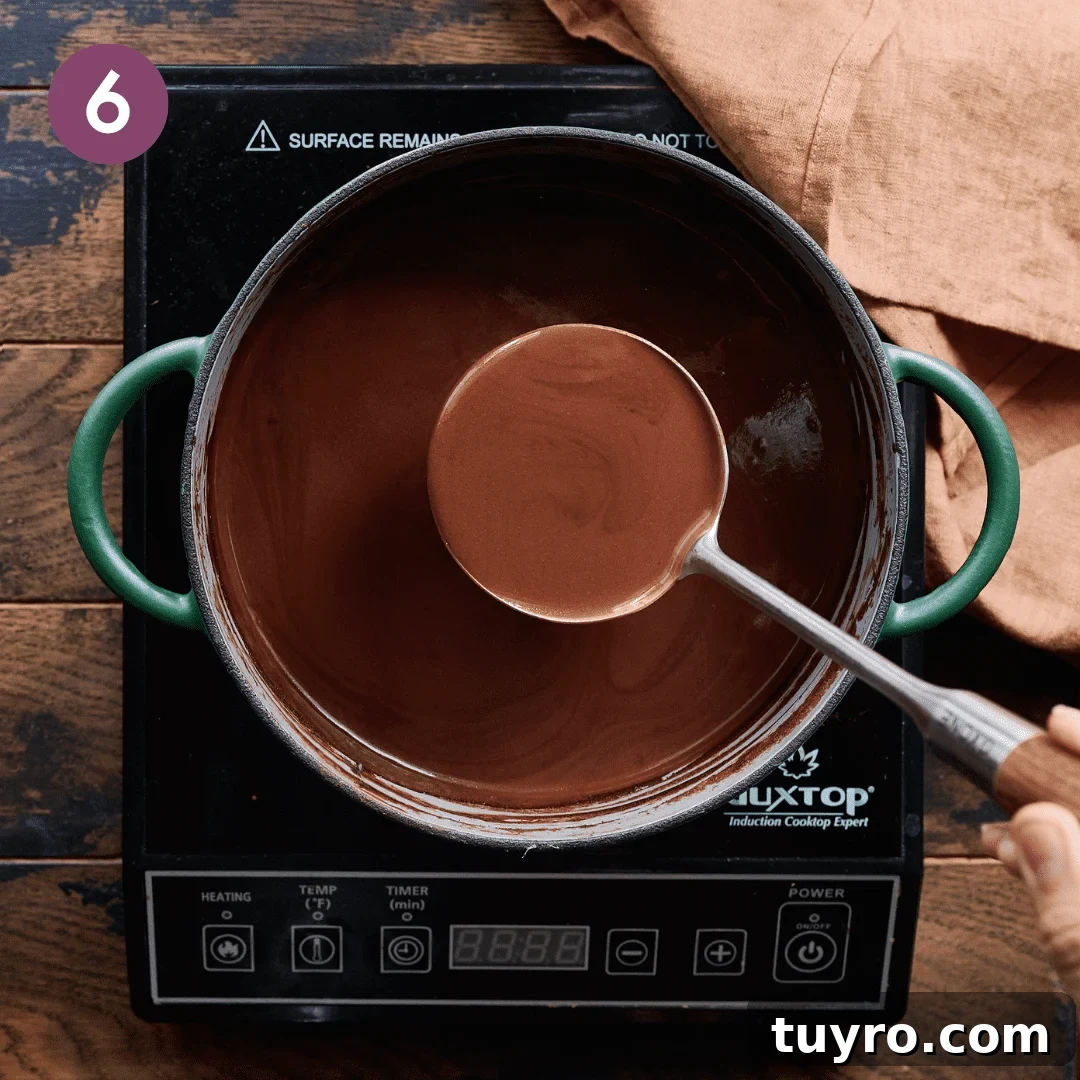 Creamy Vegan Hot Chocolate Recipe 11 Person ladeling hot chocolate out of the pot.