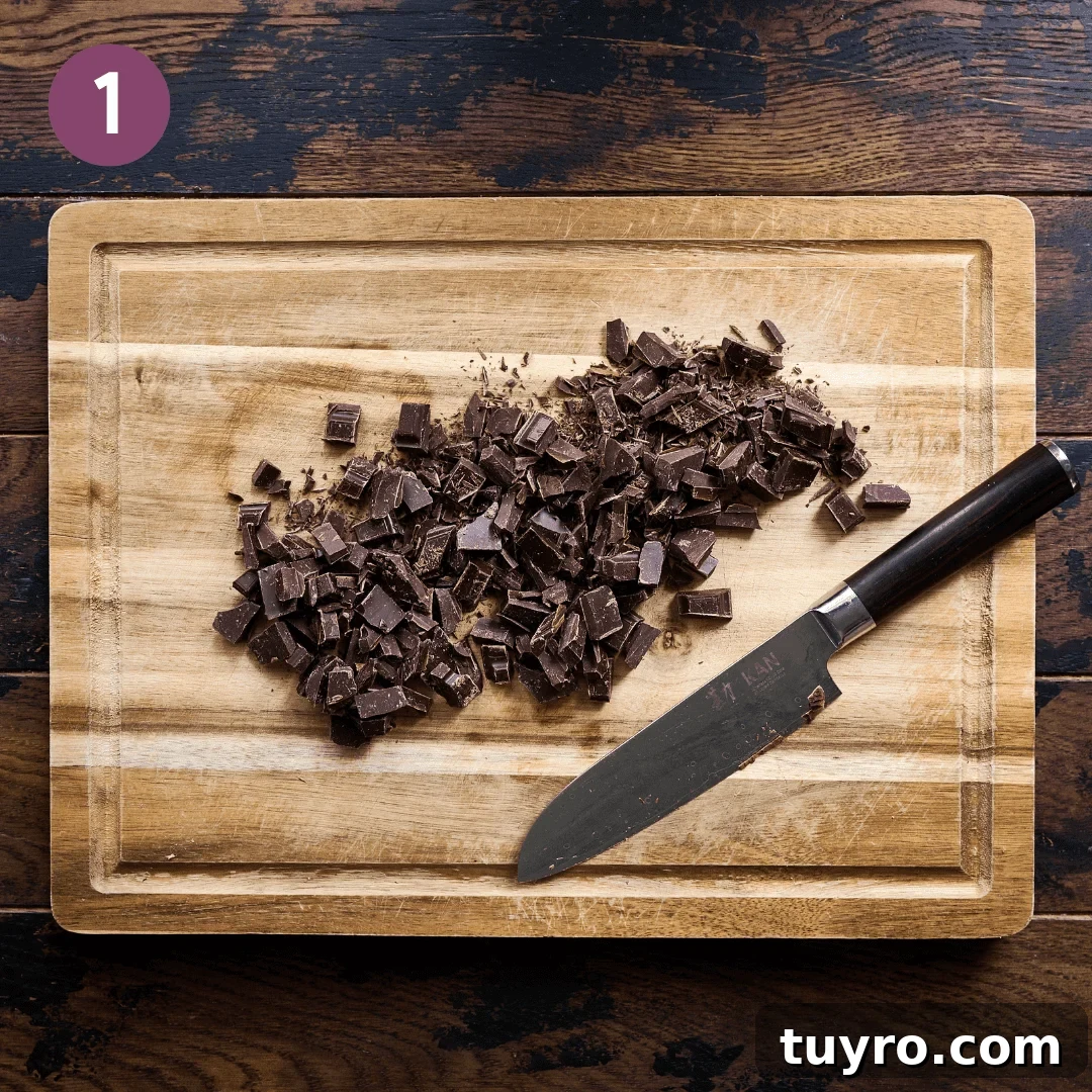 Creamy Vegan Hot Chocolate Recipe 6 Knife with chopped dark chocolate on a wood cutting board.