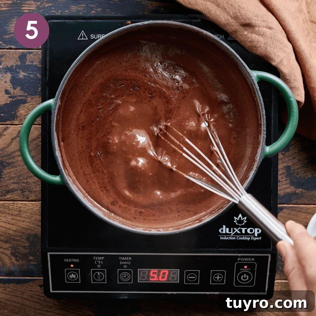 Creamy Vegan Hot Chocolate Recipe 10 Person whisking hot chocolate mixture.