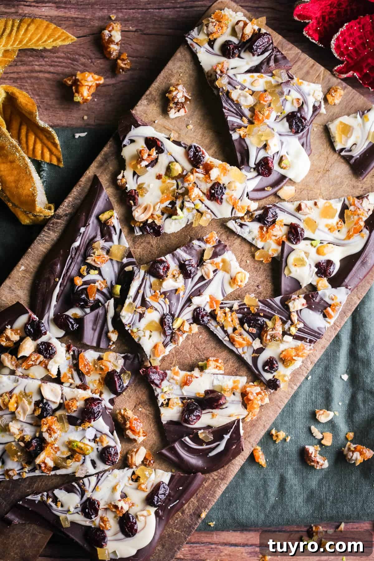 Christmas Chocolate Bark Recipe with Festive Toppings 2 Christmas Chocolate Bark snapped into shards on a wooden board.