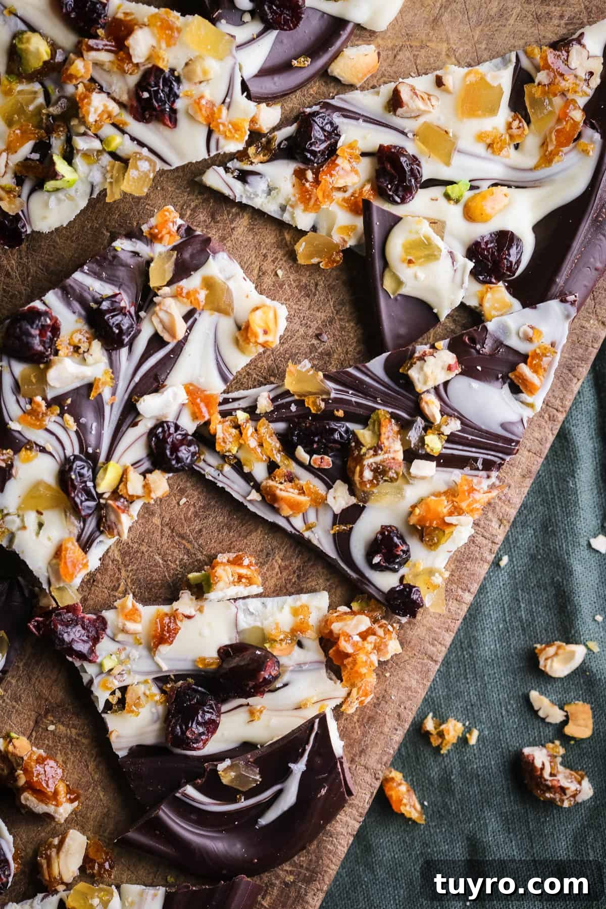 Christmas Chocolate Bark Recipe with Festive Toppings 11 Christmas Chocolate Bark snapped into shards on a wooden board.
