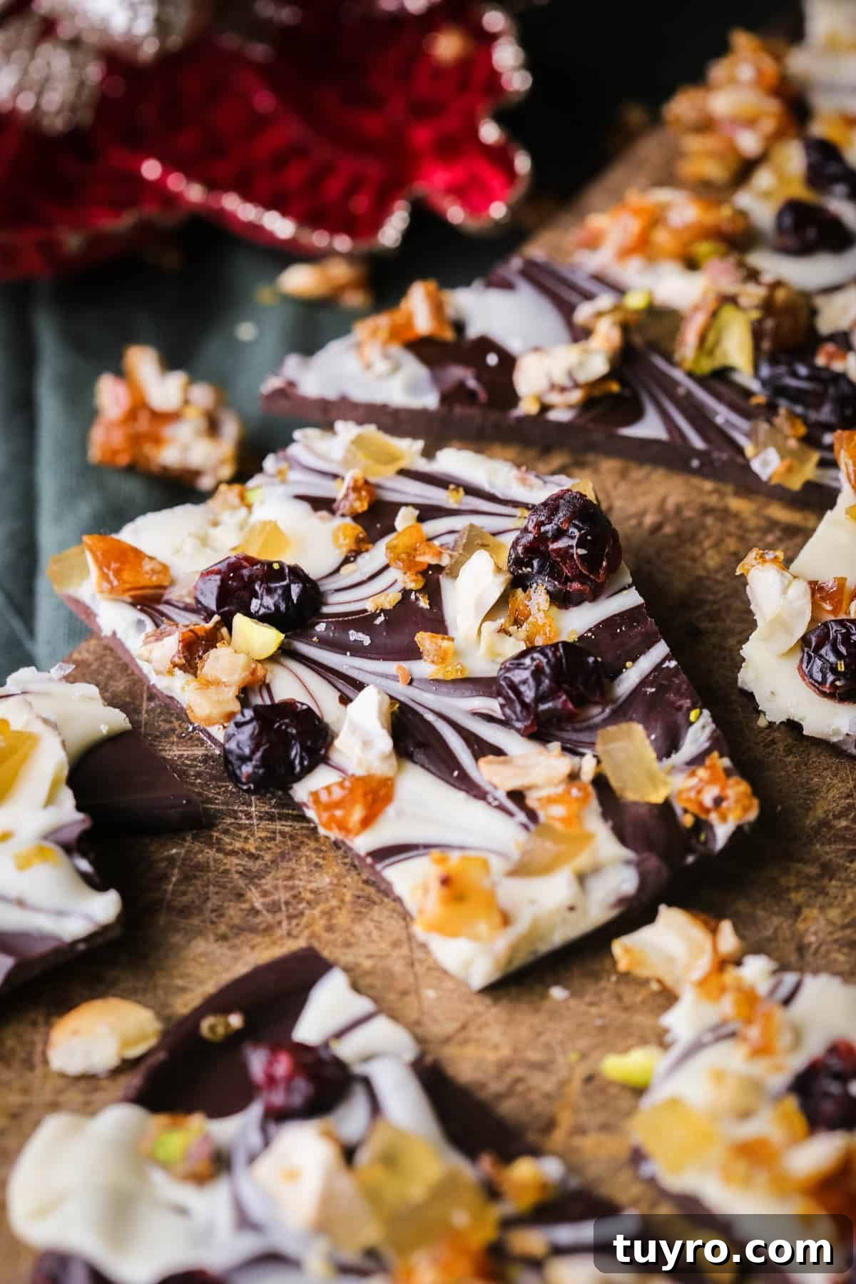 Christmas Chocolate Bark Recipe with Festive Toppings 5 Christmas Chocolate Bark snapped into shards on a wooden board.