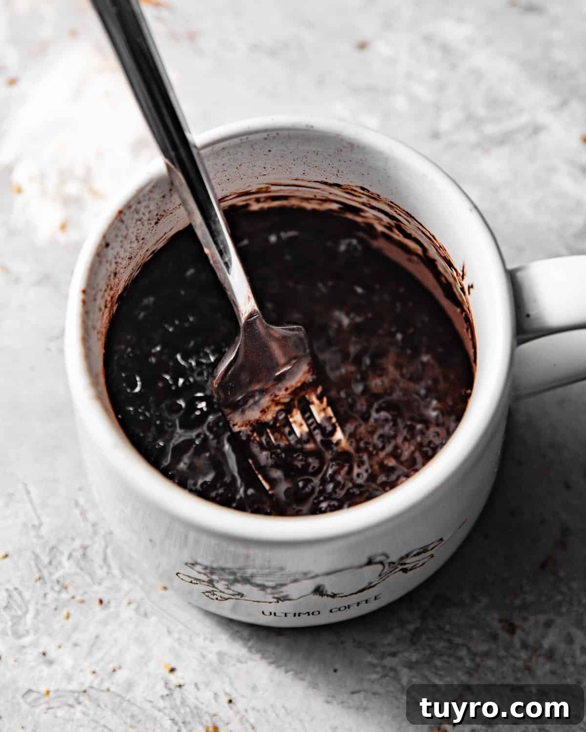 3-Ingredient Mug Cake Recipe Ready in Minutes 4 nutella and an egg in a mug mixed together with a fork.