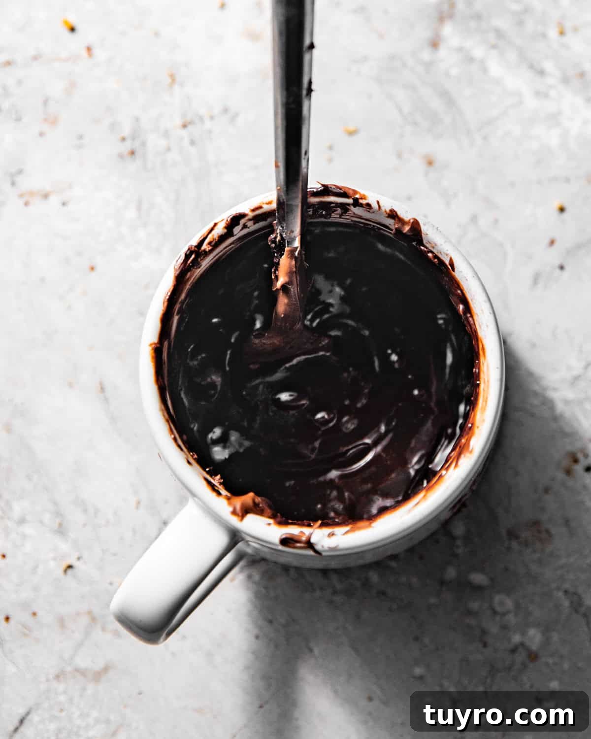 3-Ingredient Mug Cake Recipe Ready in Minutes 5 nutella, egg, and cocoa powder mixed together in a mug with a fork.