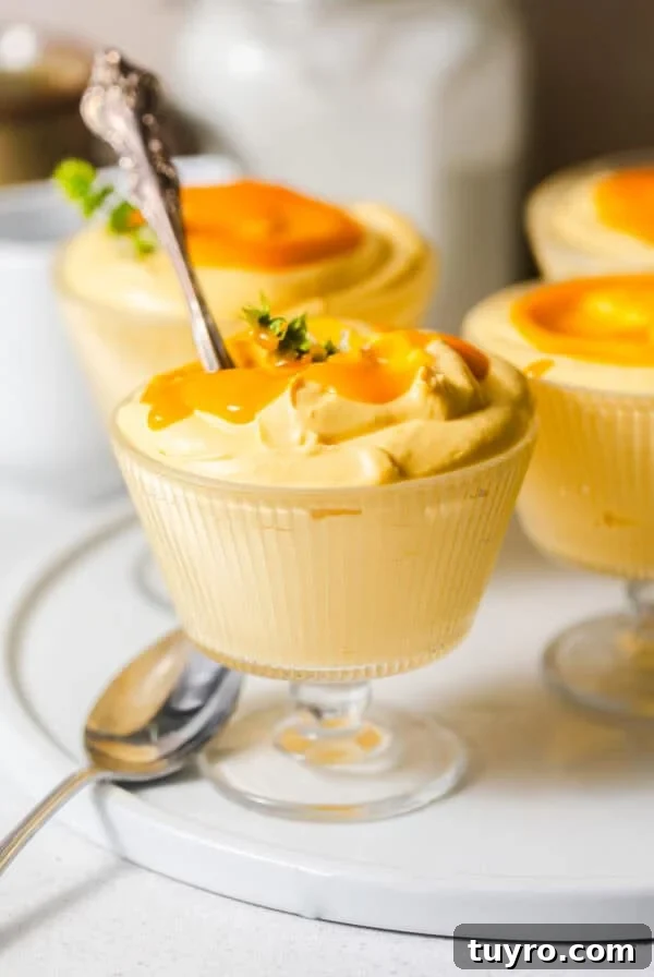 3-Ingredient Mug Cake Recipe Ready in Minutes 8 mango mousse in glass serving cups on a serving plate with spoons.