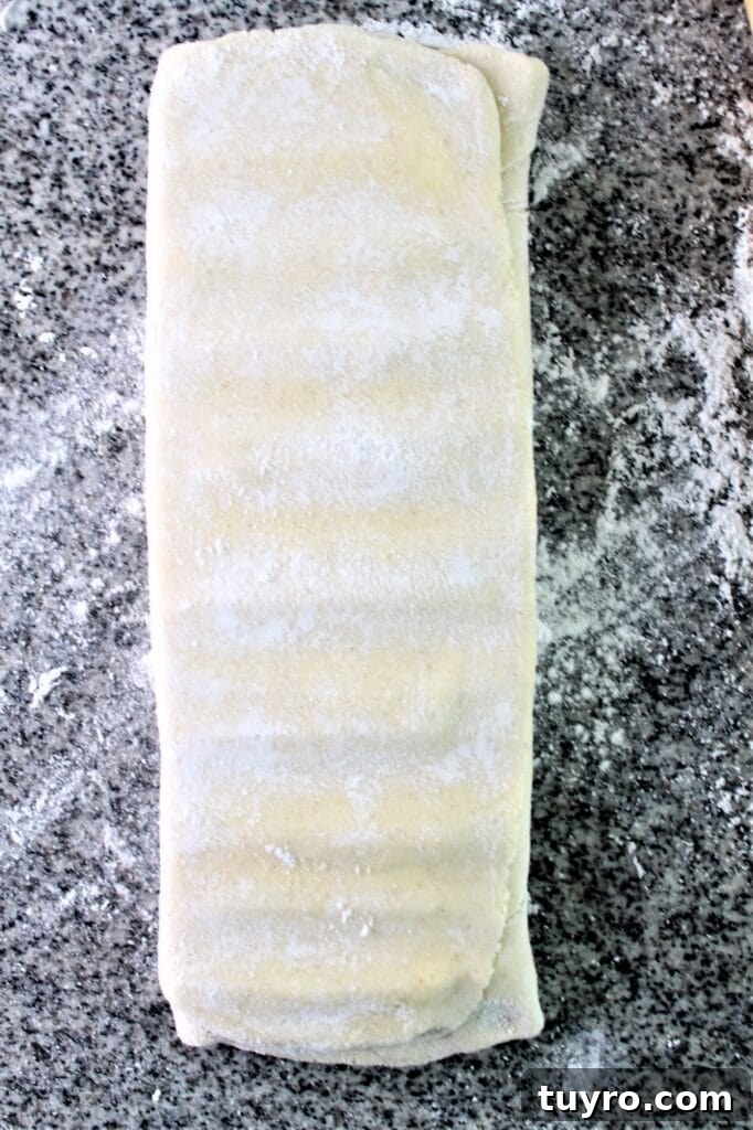 pressing the dough with the rolling pin to lengthen
