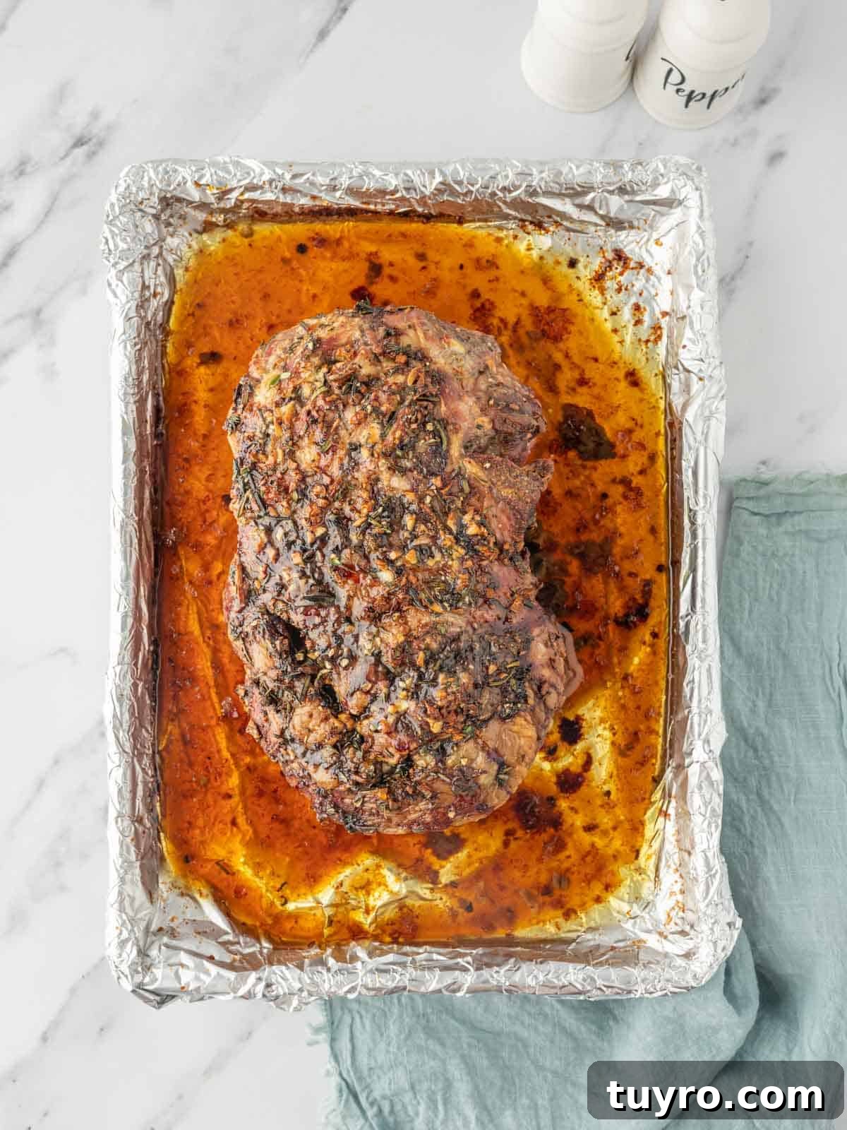 Boneless Leg of Lamb Roast Recipe: Tender, Juicy, Oven-Roasted 6 Roasted leg of lamb in its juices in a baking dish lined with foil.