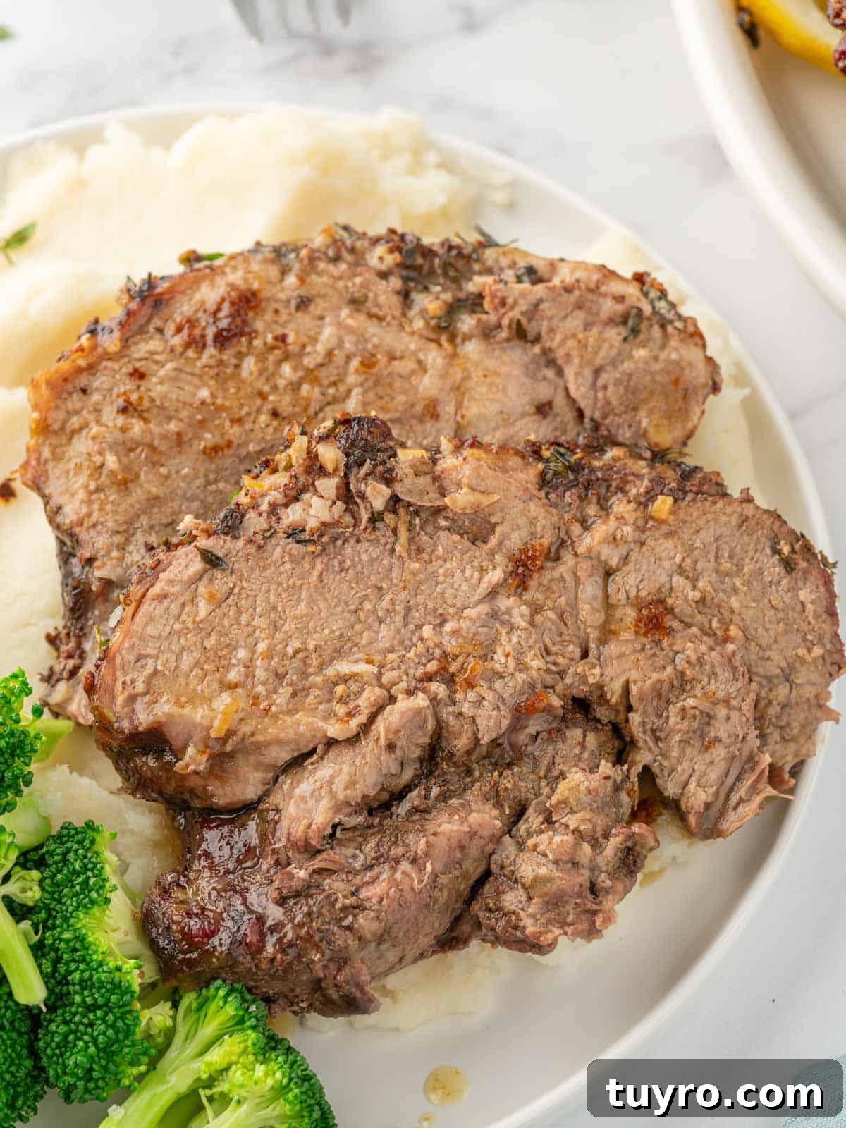 Boneless Leg of Lamb Roast Recipe: Tender, Juicy, Oven-Roasted 7 Leg of lamb slices on a plate.