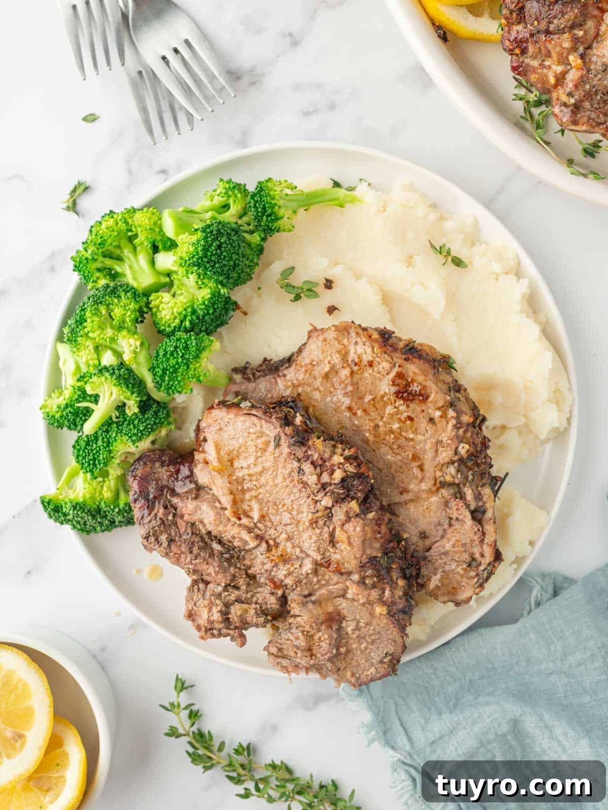 Boneless Leg of Lamb Roast Recipe: Tender, Juicy, Oven-Roasted 8 Sliced of roasted lamb on a plate with mashed potatoes and broccoli.