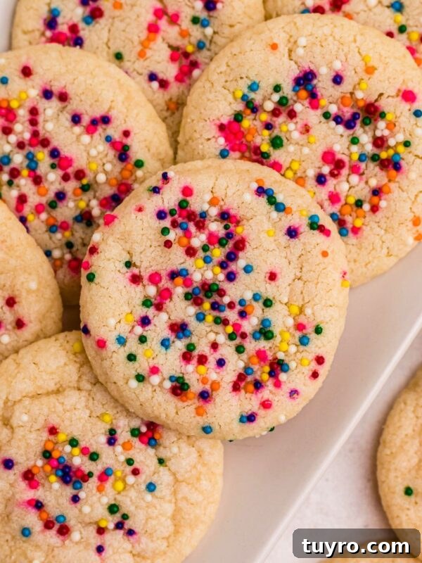 Coconut Delight: Creamy Coconut Dessert Recipe for Home Bakers 12 Sugar cookies topped with sprinkles stacked on a rectangle white plate .