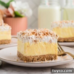 Coconut Delight: Creamy Coconut Dessert Recipe for Home Bakers 14 Slice of coconut delight on a small white plate with a fork on the side.