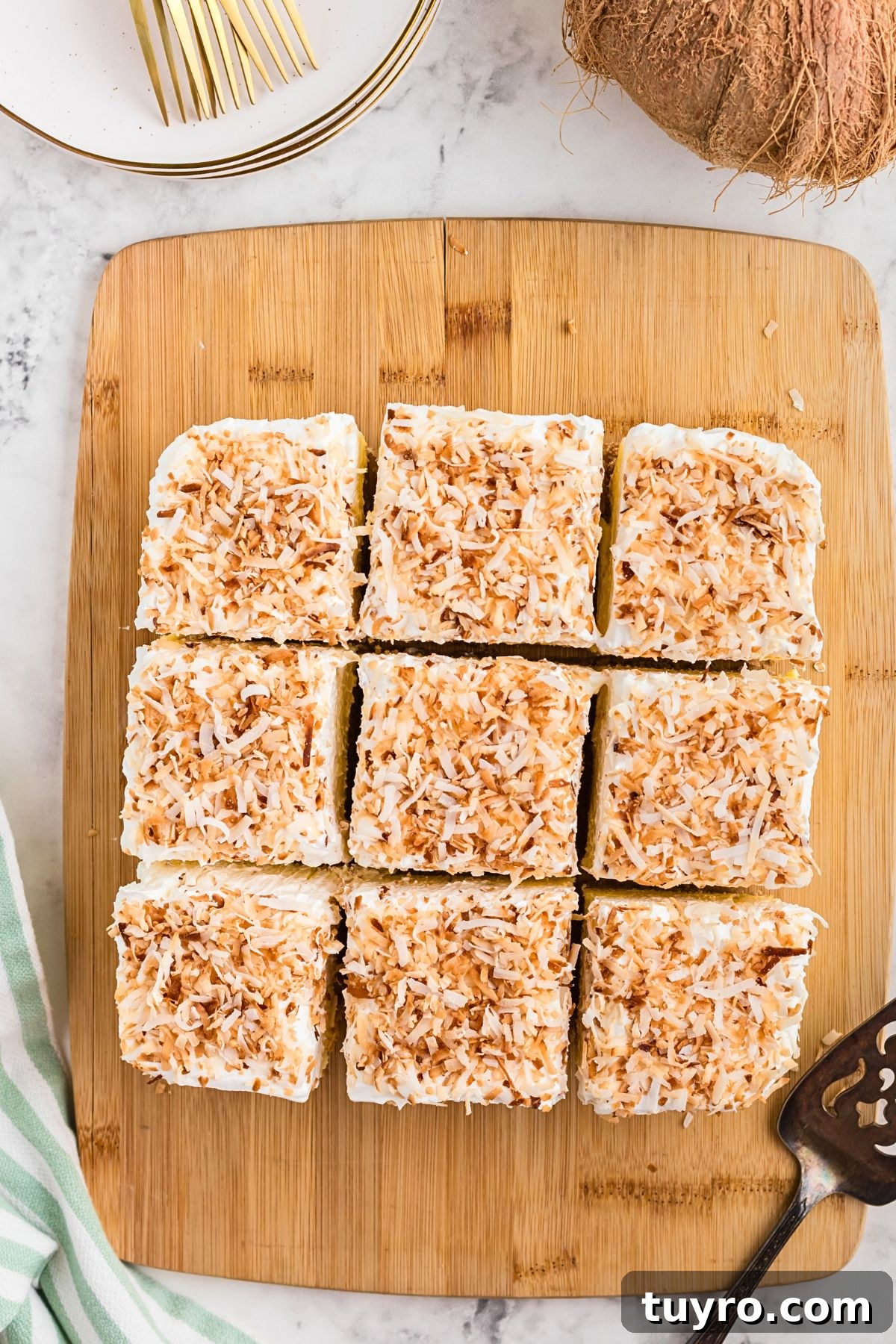 Coconut Delight: Creamy Coconut Dessert Recipe for Home Bakers 8 Coconut delight dessert on a wooden cutting board, cut into slices.
