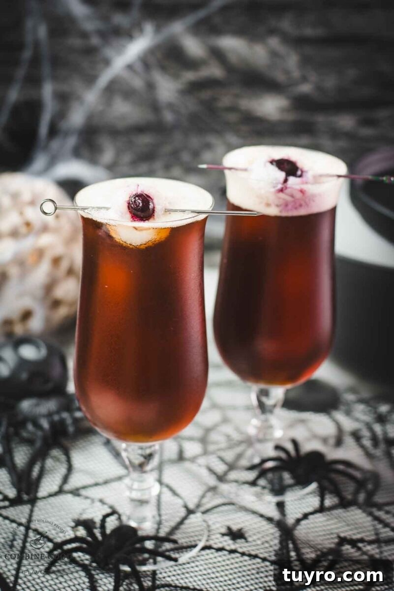 Spooky black velvet cocktail, garnished with eerie lychee eyeballs.