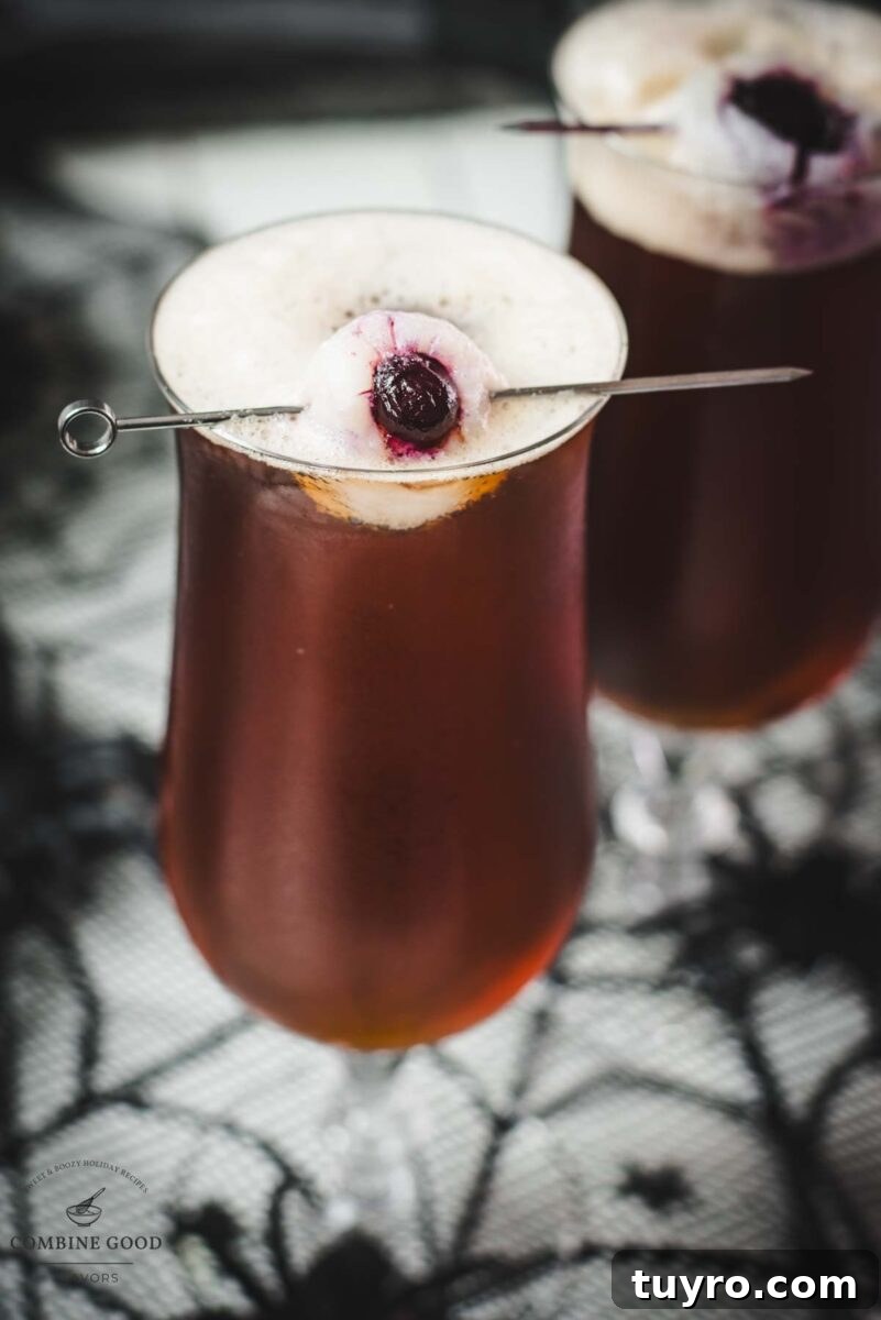 Spooky black velvet cocktail, garnished with eerie lychee eyeballs.