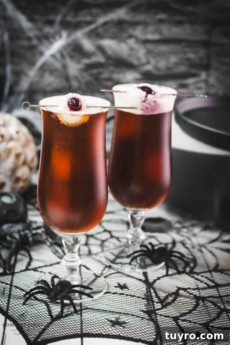 Spooky black velvet cocktail, garnished with eerie lychee eyeballs.