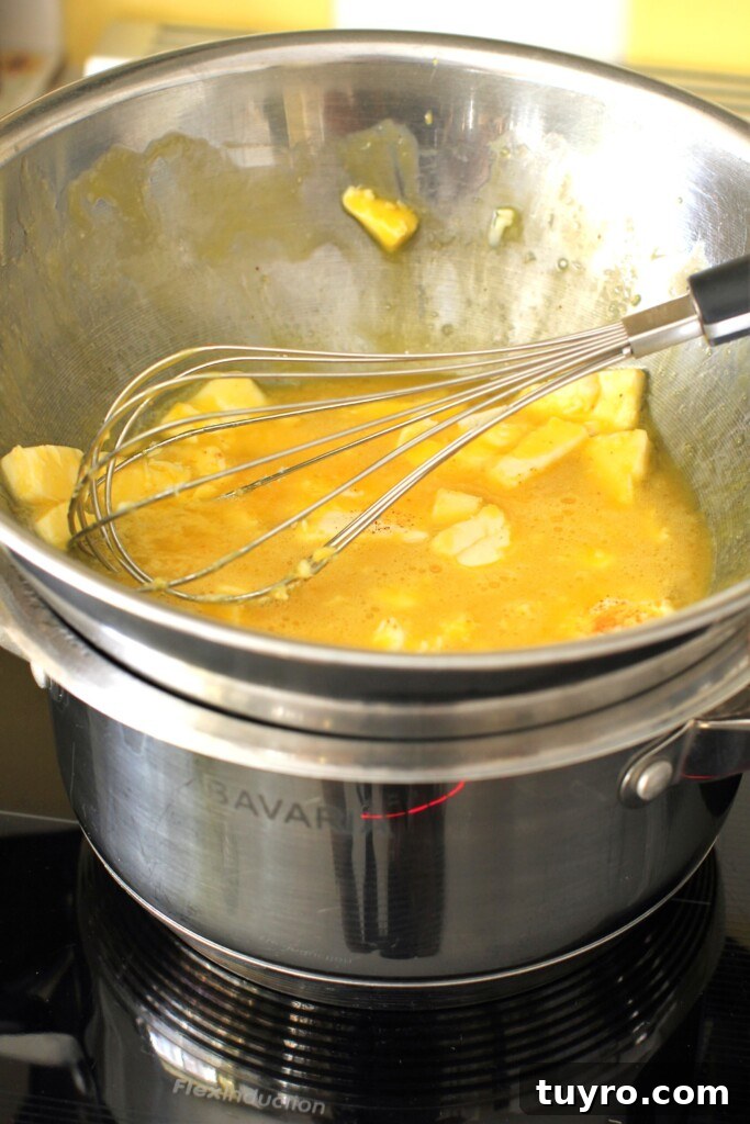 Classic Hollandaise Sauce Recipe for White Asparagus 8 A bowl of Hollandaise sauce set over a pot of simmering water ready to whisk and heat.