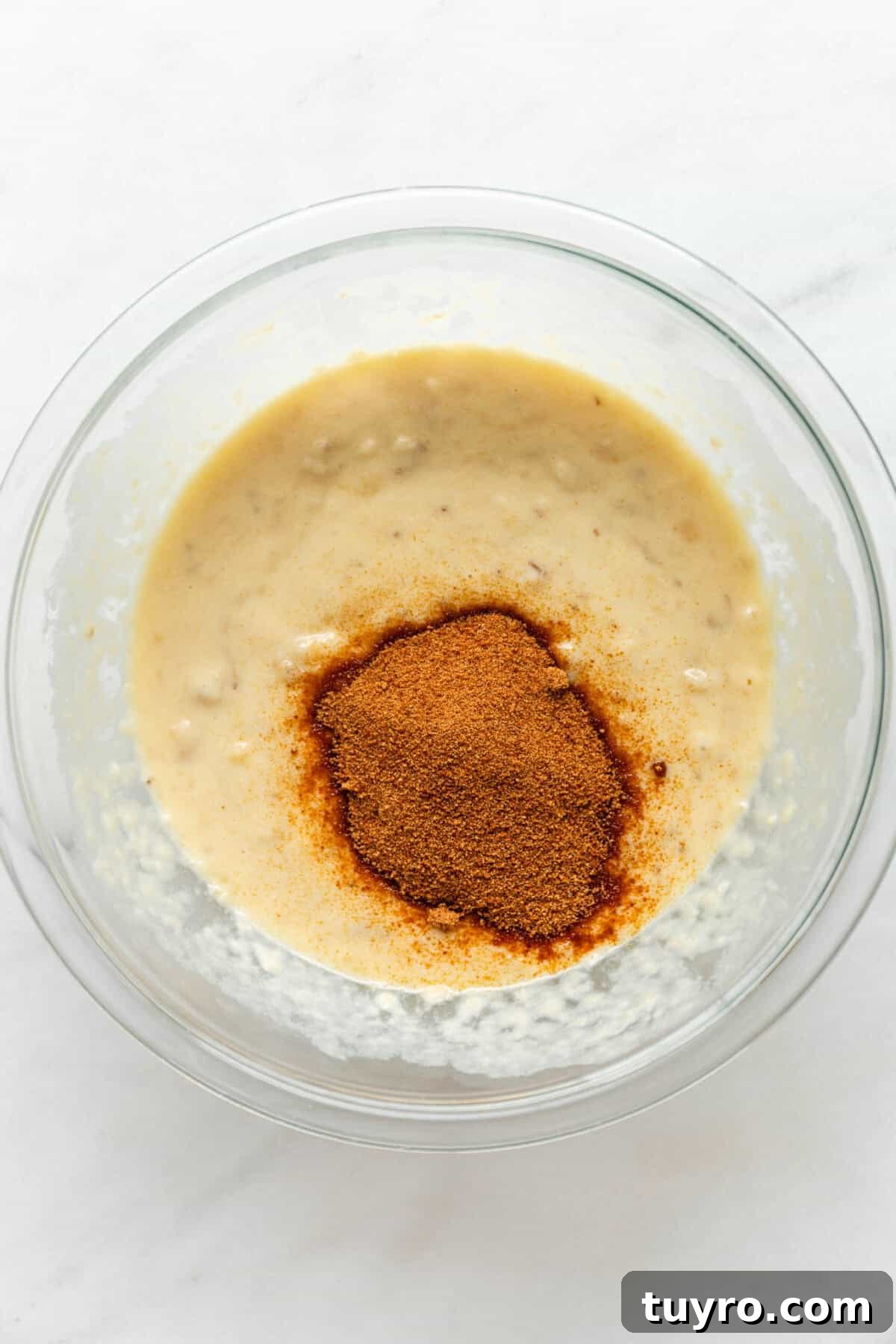 High-Protein Banana Muffins for Quick Breakfast and Snacks 5 mashed banana, egg and yogurt mixture with coconut sugar in a bowl.