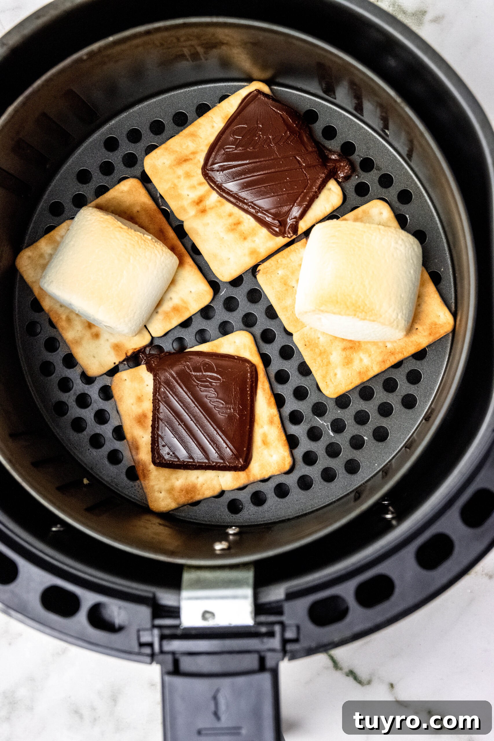 Air Fryer Smores Recipe 3 Overhead of air fryer basket with smores ingredients.