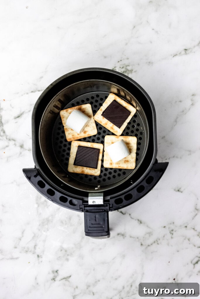 Air Fryer Smores Recipe 6 Marshmallows and chocolate arranged on graham crackers.